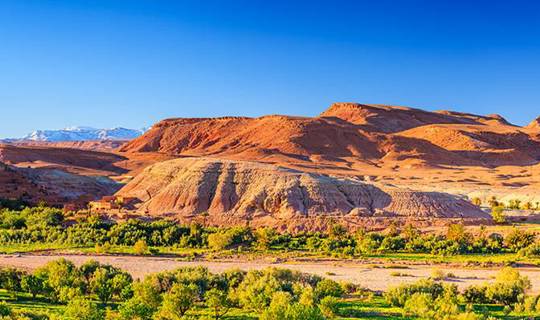 Vista of walled city and low hill in Morocco