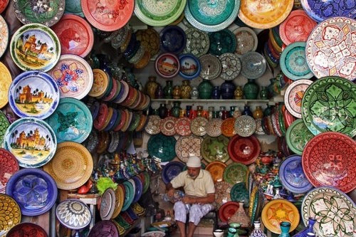 Man selling colourful plates on a market in Morocco