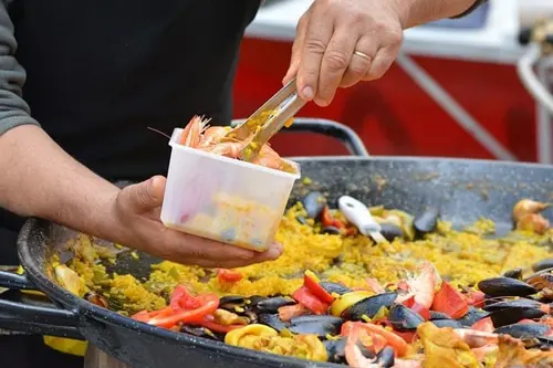 Someone putting paella in a box